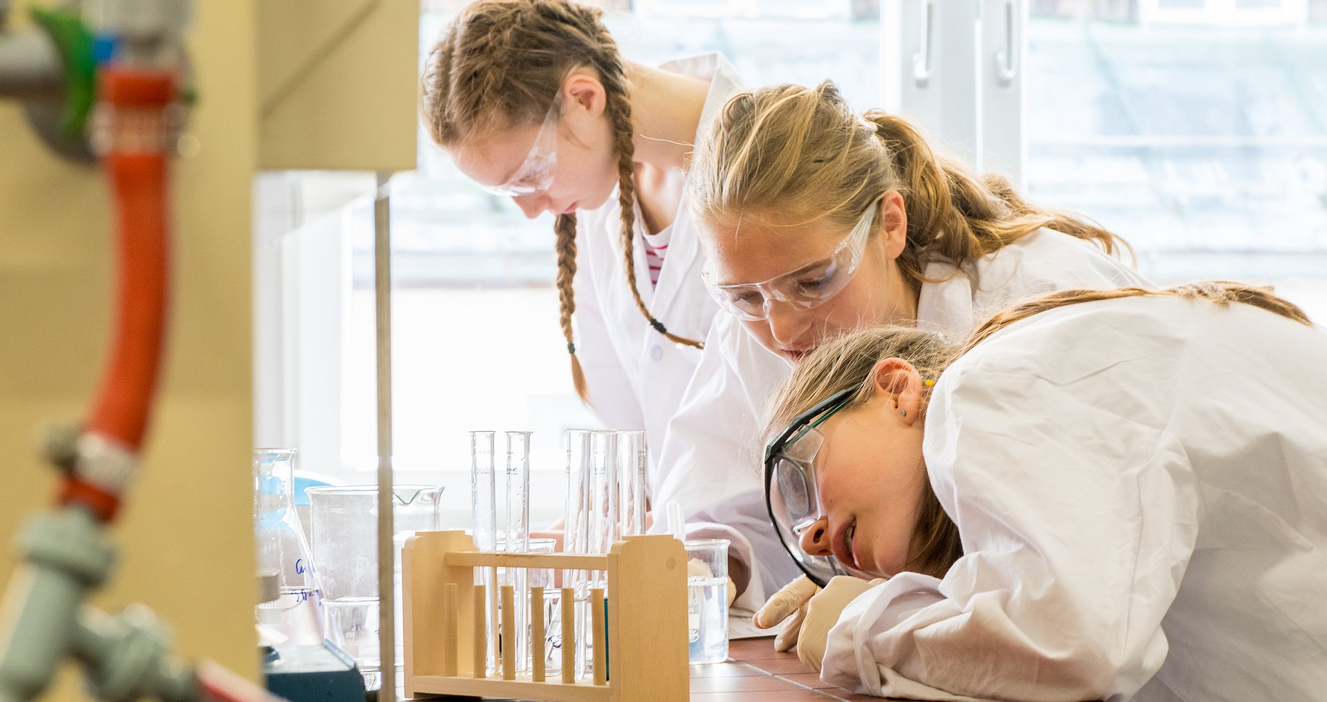Drei Mädchen experimentieren im Chemielabor.