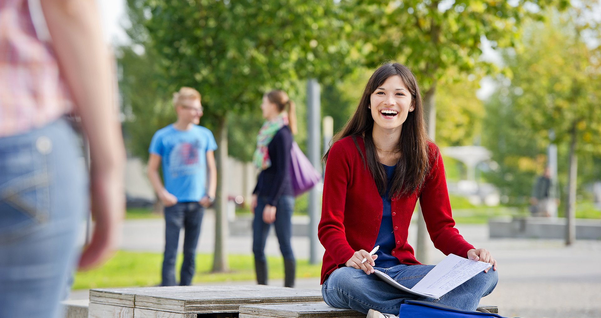 A girl sits at the campus studying.