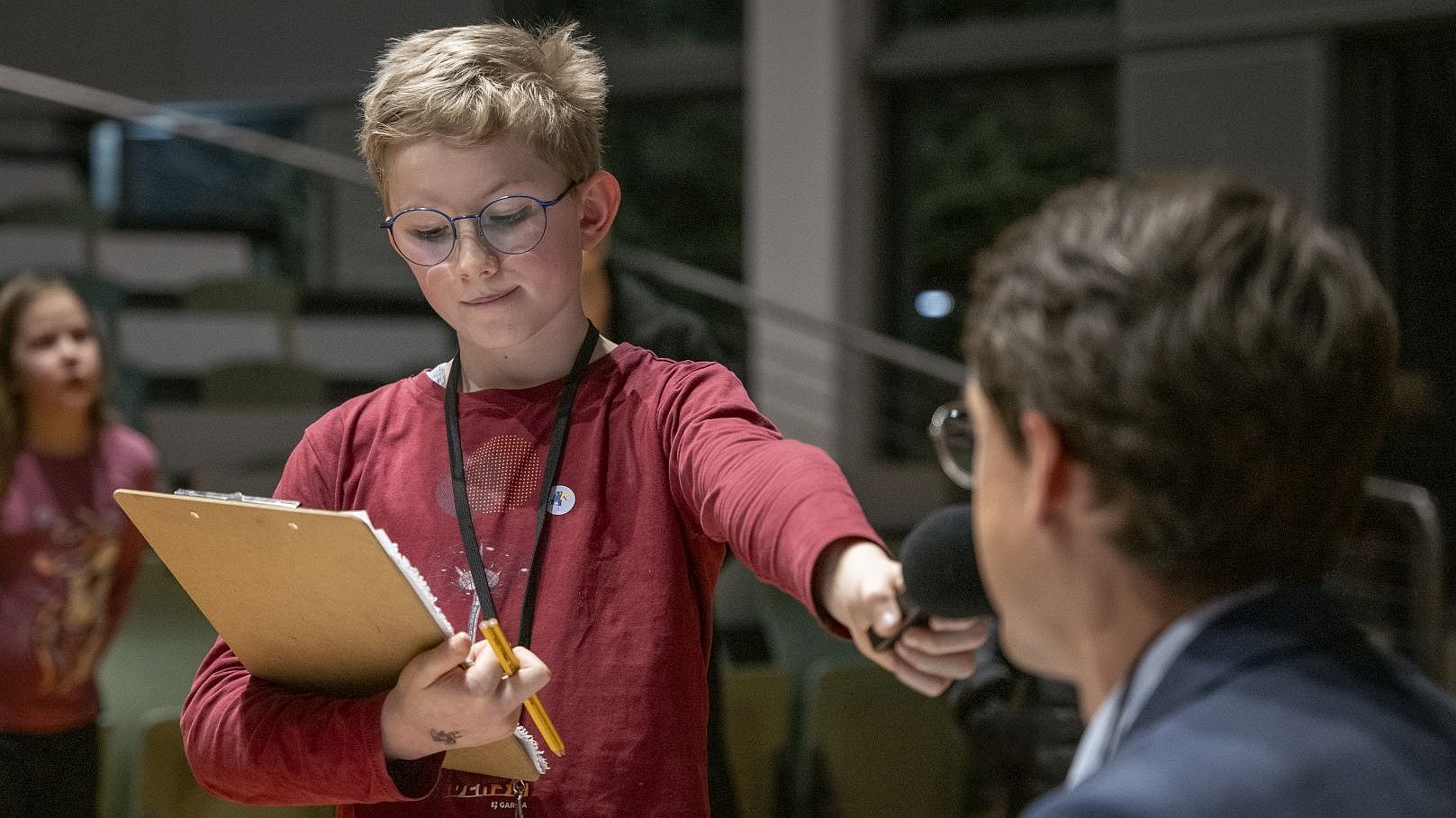 A child reporter conducts an interview with Prof. Reiss