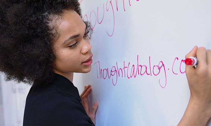 Junge Frau schreibt an ein Whiteboard