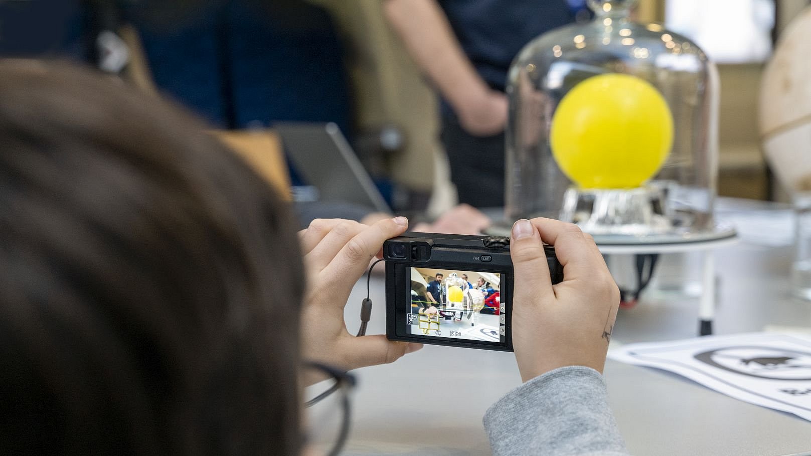 A child photographs a vacuum experiment