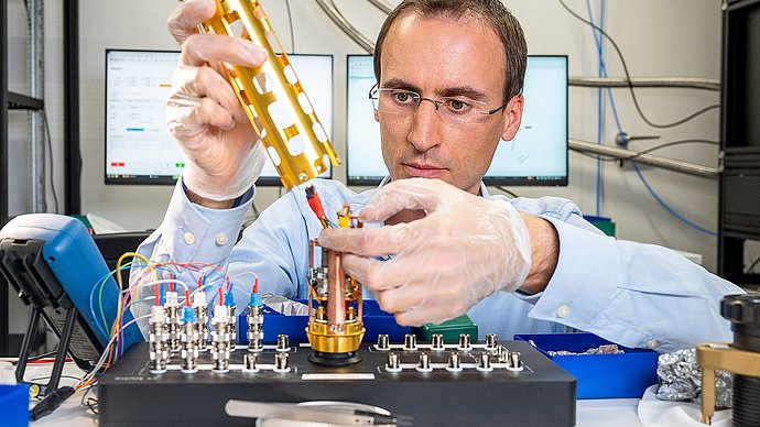 Prof. Andreas Reiserer in his lab with an experimental setup.