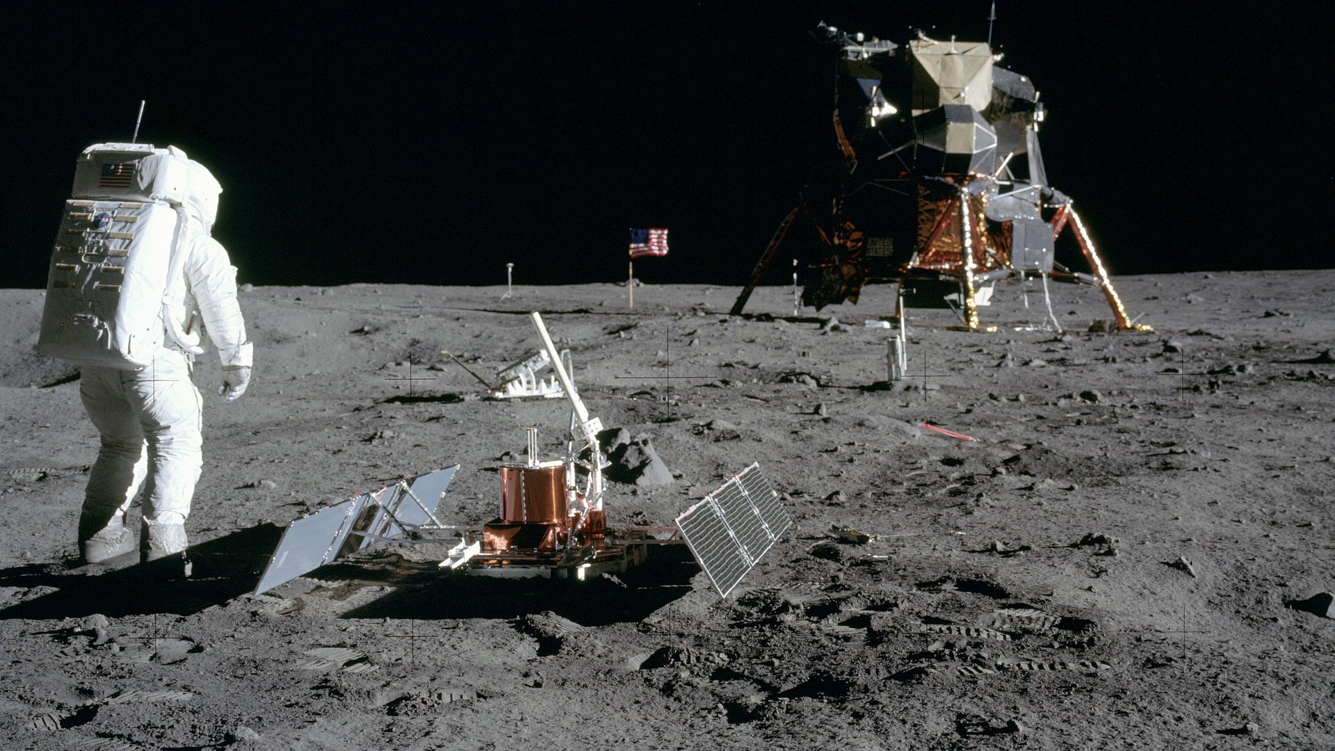 Zu sehen ist Astronaut Buzz Aldrin, der gerade das Seismometer aufgebaut hat (vorne). Dahinter steht der Laser Ranging Retro-Reflector (LR-3).
