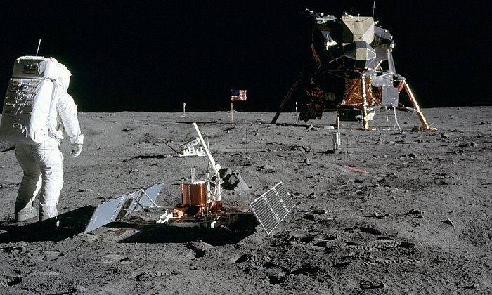 Zu sehen ist Astronaut Buzz Aldrin, der gerade das Seismometer aufgebaut hat (vorne). Dahinter steht der Laser Ranging Retro-Reflector (LR-3).