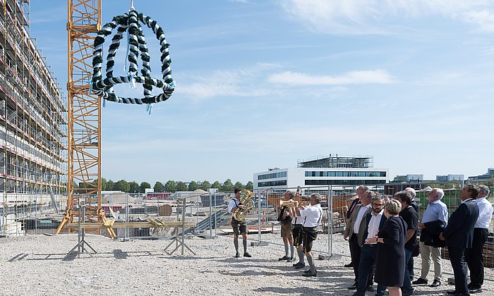 Die Richtkrone wird am EI-Neubau emporgezogen