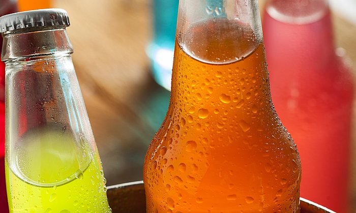 Bottles filled with colorful soft drinks.