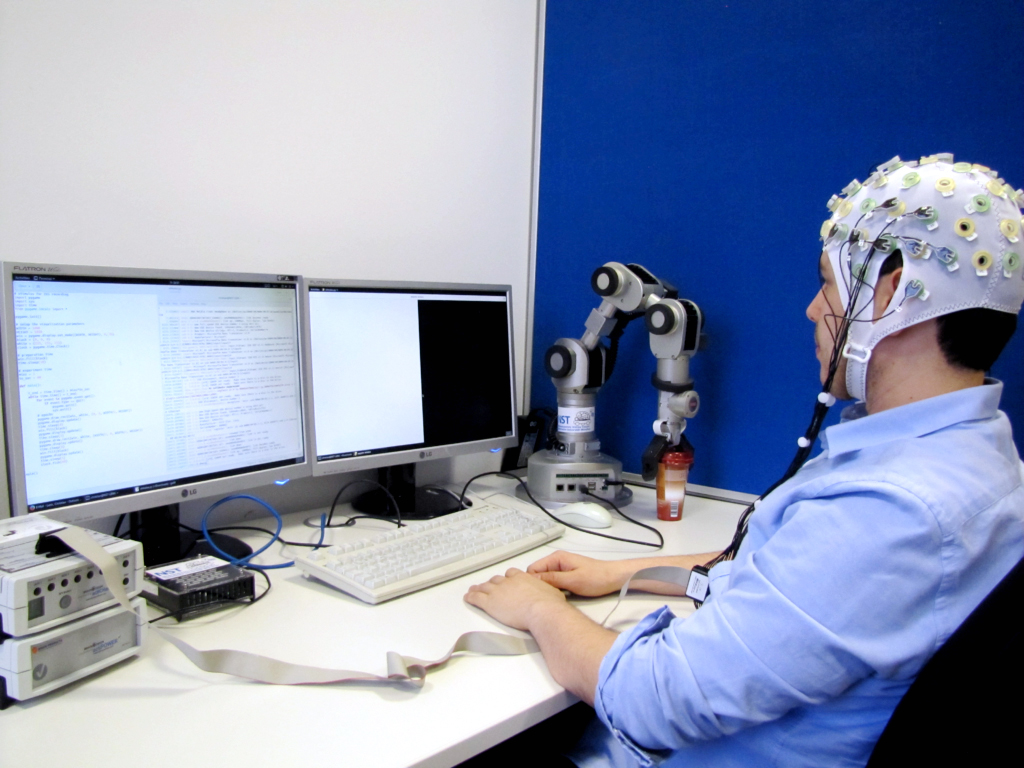 A researcher is connected to a computer via a brain-computer-interface.Gehirn-Rechner-Schnittstelle mit einem Rechner verbunden.