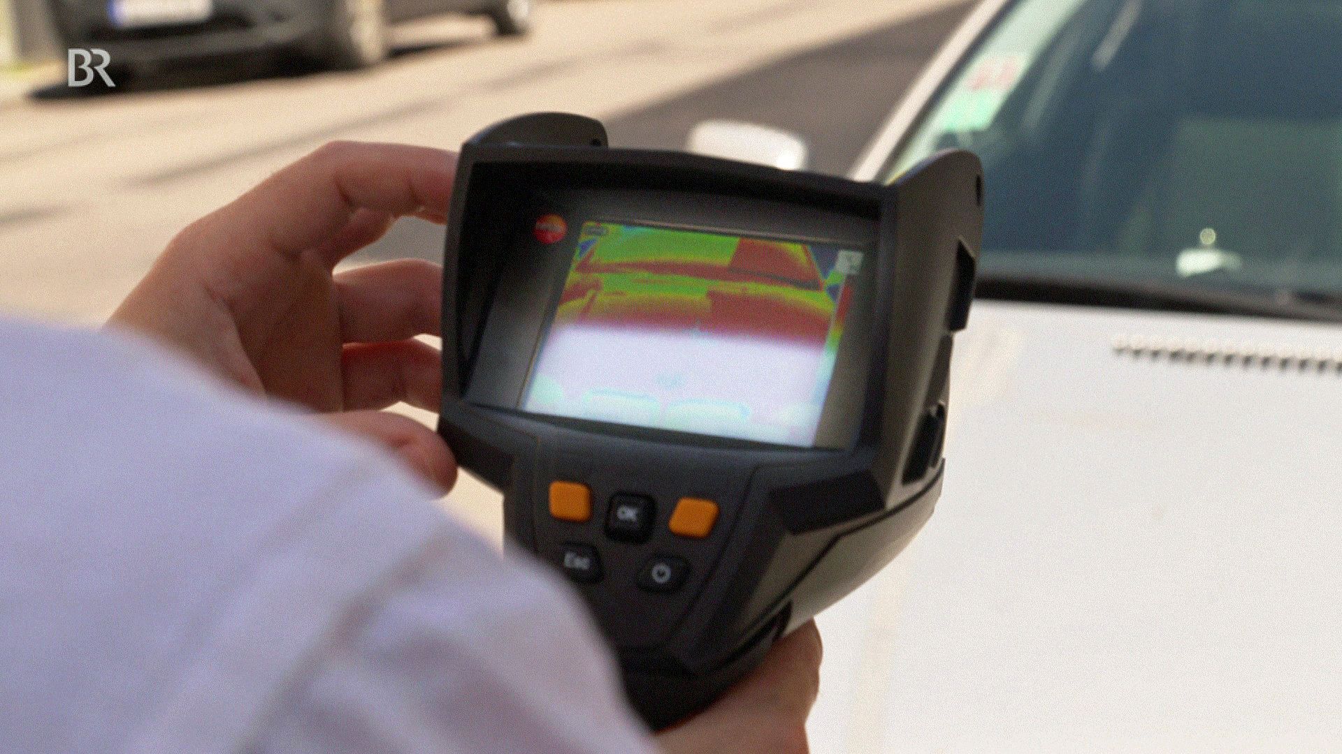 Hitze in der Stadt. Forscher misst die Oberflächentemperatur eines Autos.
