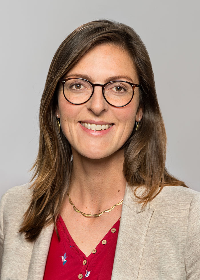  Photo of a woman with long, straight, dark hair and glasses. She is wearing a light-colored jacket and is the contact person for the Deutschlandstipendium scholarship