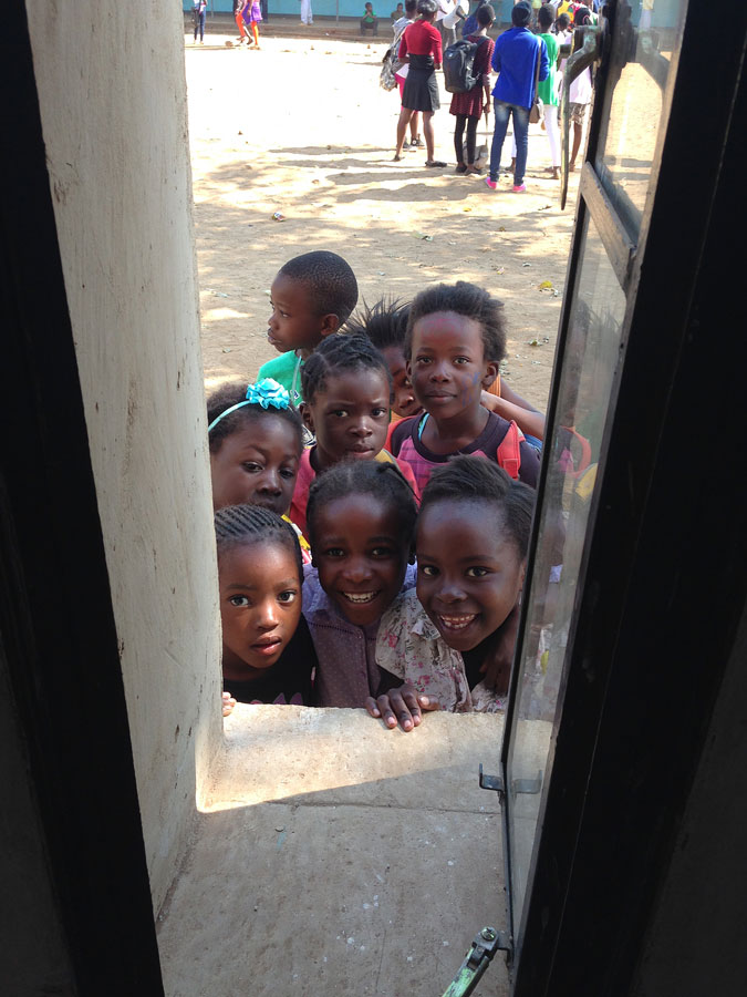 Gespannte Blicke durch's Fenster: TUM-Studenten entwickeln in Sambia ein neues Schulgebäude mit, das einmal im ganzen Land gebaut werden könnte. (Foto: Klaus Mindrup)