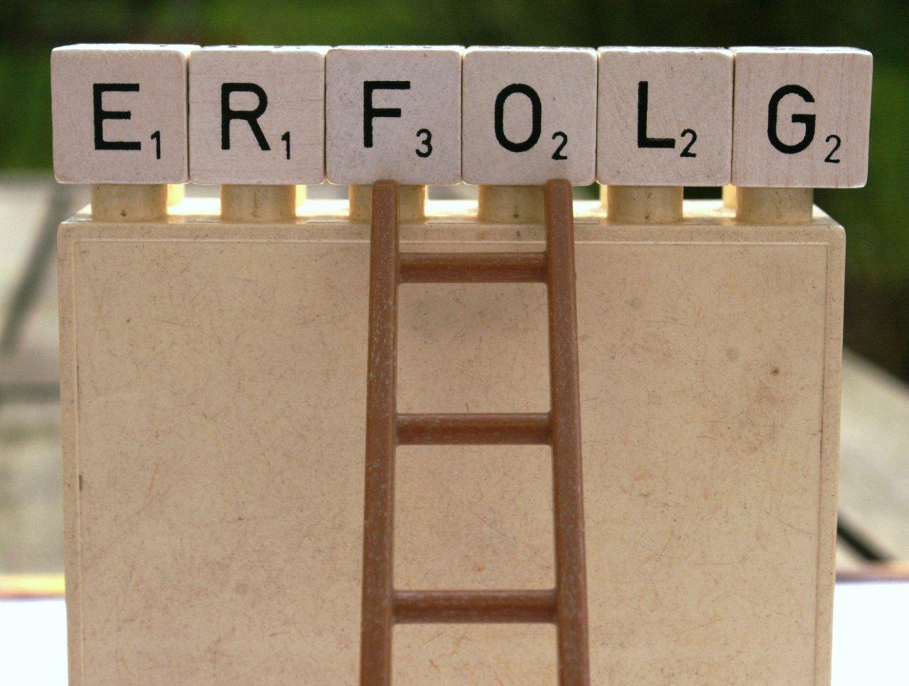 Schriftzug "Erfolg" und Holzleiter