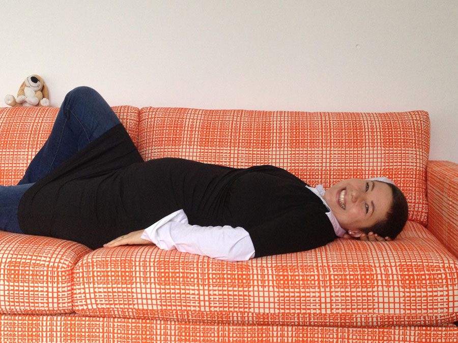 A pregnant woman lying on a sofa