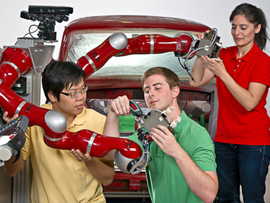 Junge internationale Wissenschaftler arbeiten an einem Roboter.