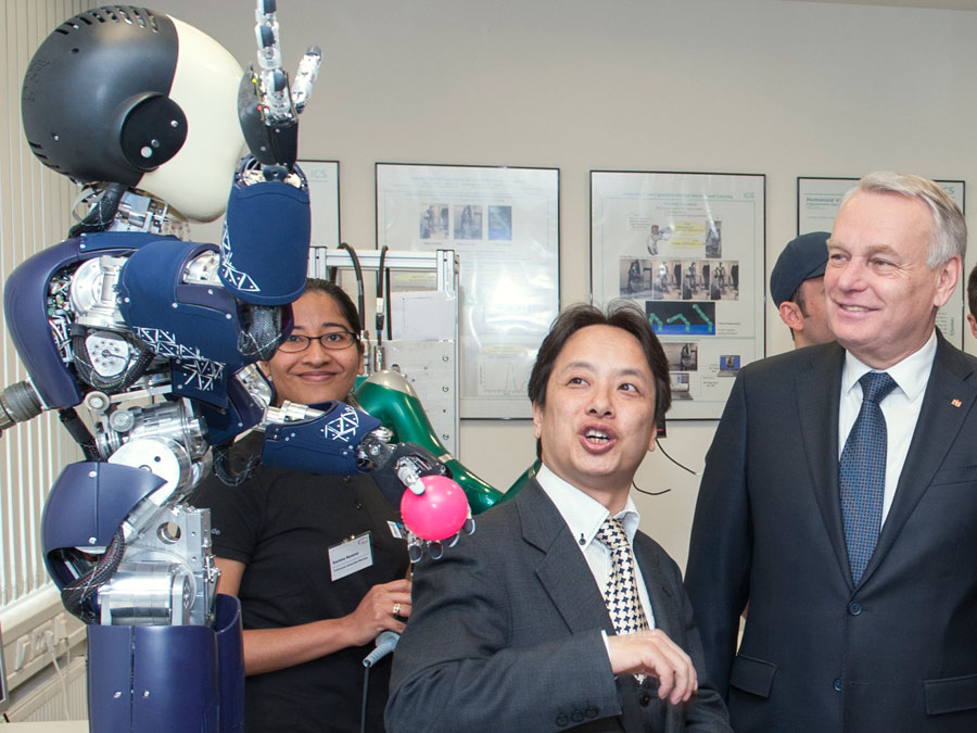 Prof. Gordon Cheng und Frankreichs Premier Jean-Marc Ayrault mit dem Roboter ICub.