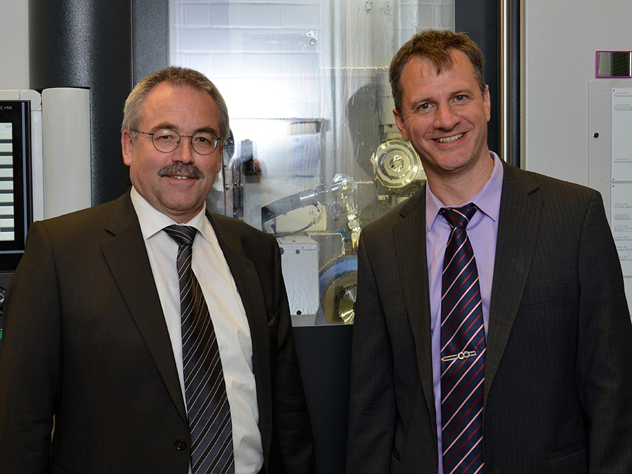 Dr.-Ing A. Mundt und Prof. Dr.-Ing. Karsten Stahl vor der Liebherr LGG 280 Zahnradschleifmaschine – Bild: Andreas Battenberg / TUM