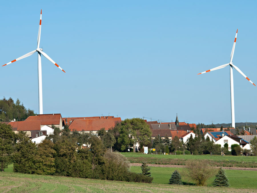 Windräder neben einem Dorf