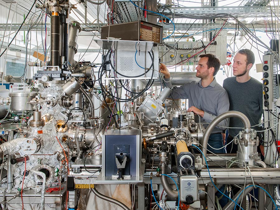 Andrew Crampton and Marian Rötzer at their vacuum chamber for production of ultra-small catalyst particles - Photo: Andreas Heddergott / TUM