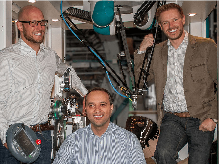 Cevotec founders Felix Michl, Neven Majic, and Thorsten Gröne with the prototype of their production system.