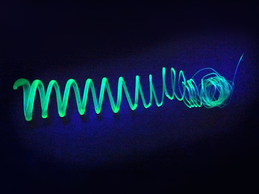Extrudierte Spirale aus polymerumhüllten Silizium-Nanoblättchen unter UV-Licht - Bild: Tobias Helbich / TUM