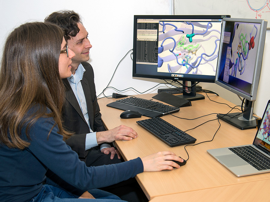 Sophie Mader und Prof. Ville Kaila; auf den Bildschirmen die Simulation der beiden AsqJ-Modelle. (Bild: A. Battenberg / TUM)