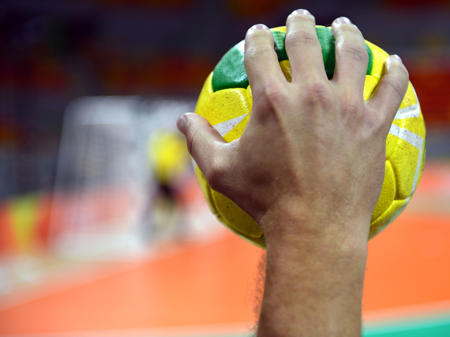 Eine Hand hält einen Handball.