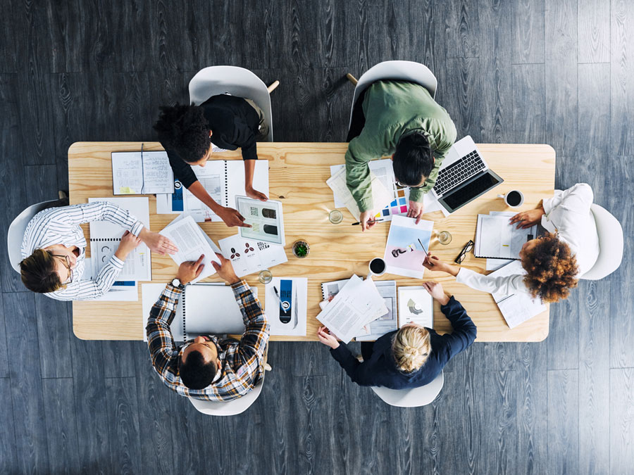 Wer arbeitet nach eindeutigen Werten? Der "IKOM Award" macht auf kleinere Unternehmen aufmerksam. (Bild: istockphoto.com / Dean Mitchell) Blick von oben auf eine Gruppe am Bürotisch. (Bild: istockphoto.com / Dean Mitchell)