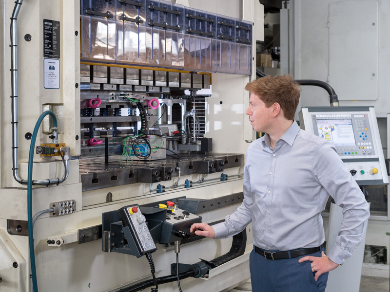 Hannes Weiss am Stanzautomaten. An dieser Maschine schneiden die Wissenschaftler die Elektrobleche mithilfe komplexer Werkzeuge. (Foto: Andreas Heddergott / TUM) Hannes Weiss am Stanzautomaten. An dieser Maschine schneiden die Wissenschaftler die Elektrobleche mithilfe komplexer Werkzeuge.