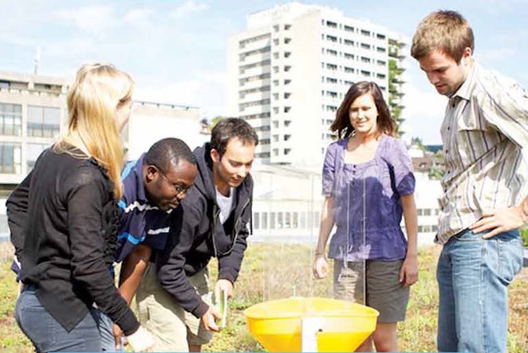 Eine Gruppe Studierende, welche ein Experiments auf einem Feld durchführt.