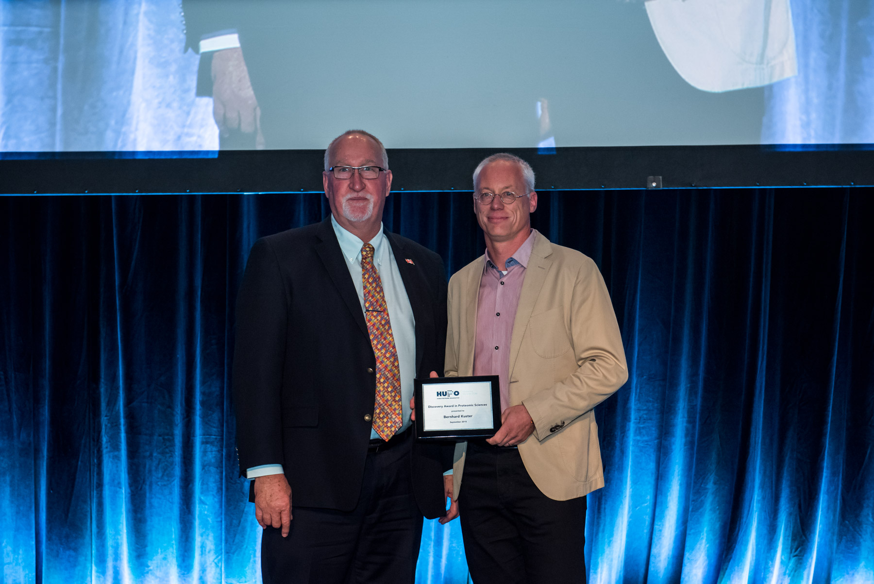 HUPO-Präsident Professor Mark Baker (l.) überreicht Professor Bernhard Küster vom TUM-Lehrstuhl für Proteomik und Bioanalytik den HUPO Discovery in Proteomic Sciences Award 2015. (Foto: Jon Benjamin)