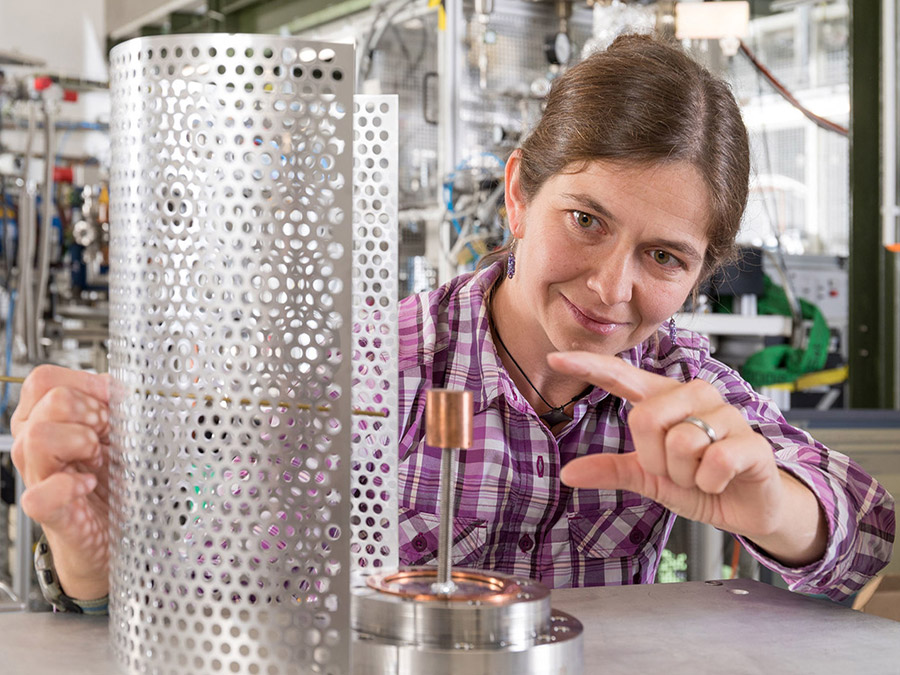 Dr. Eve Stenson demonstriert an Ersatzteilen, wie die Positronen-Falle aufgebaut ist. (Bild: Axel Griesch / IPP)