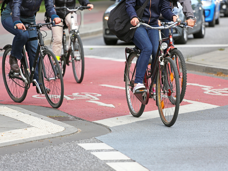 Radfahrer fahren auf einem rot markiertem Radweg.