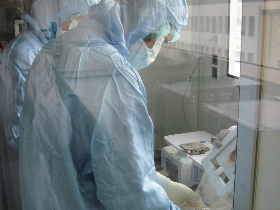 As work with cells requires highly-pure working conditions, the scientists wear sterile clothing in the clean rooms. (Photo: M. Neuenhahn / TUM)