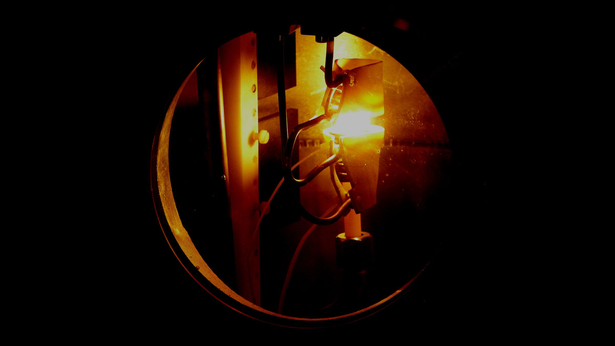 Ein glühender Metalltropfen schwebt zwischen zwei Spulen im Neutronenstrahl. (Foto: Andrea Voit/TUM)