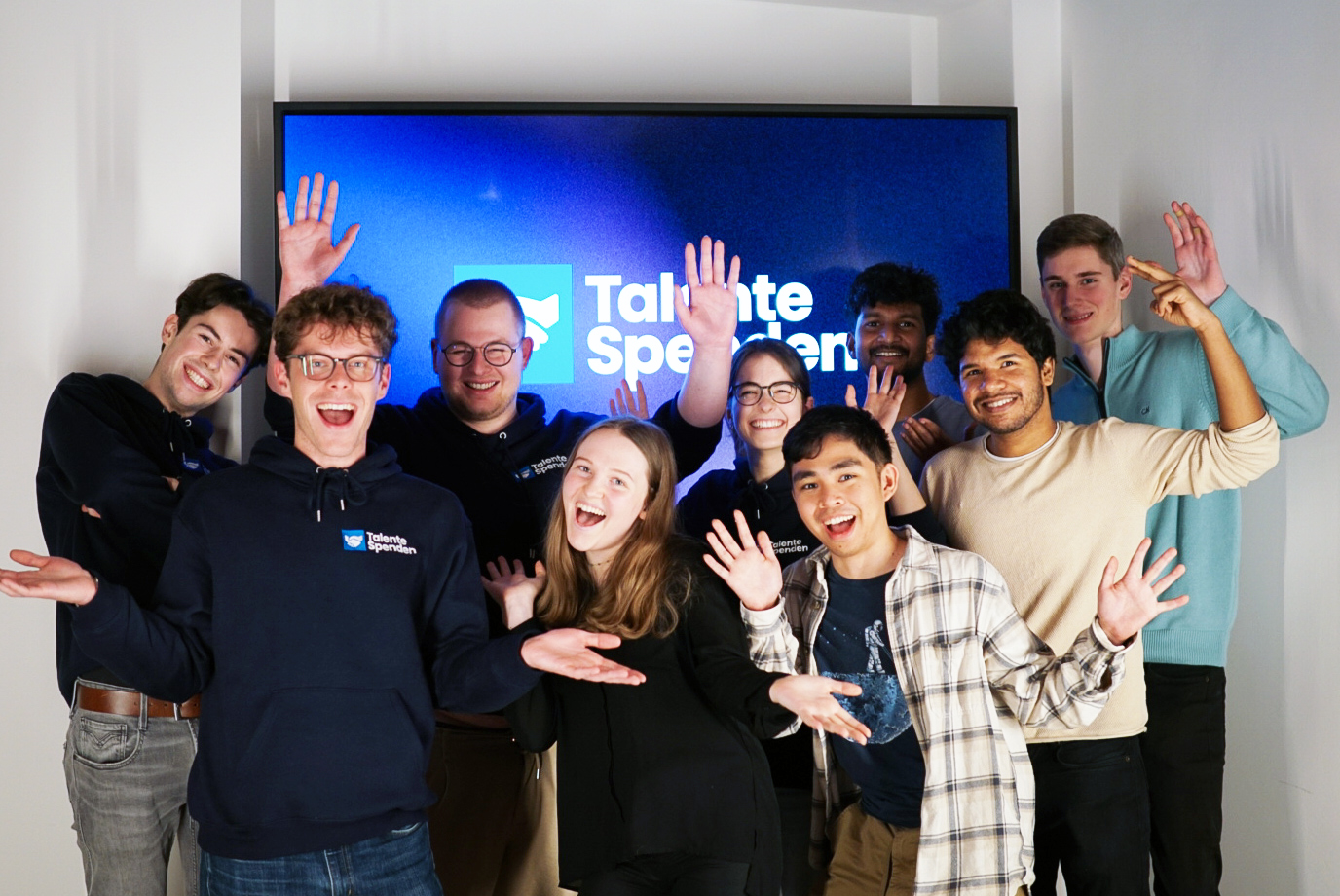 A group of students in front of the Talente Spenden e.V. logo