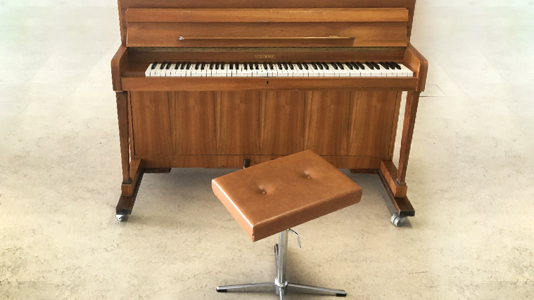 One of the pianos provided at the Munich campus with a piano stool in front of it