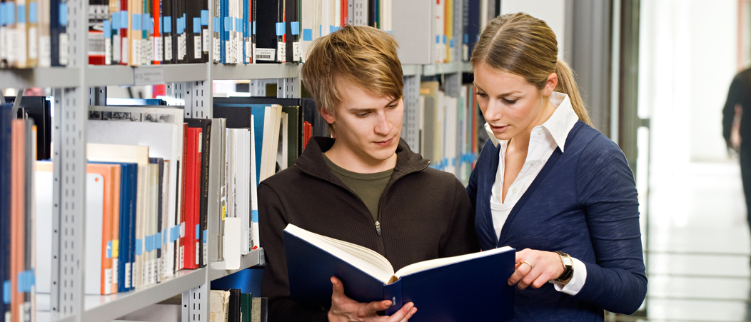 Two Students reading in a book in the library. Two Students reading in a book in the library.
