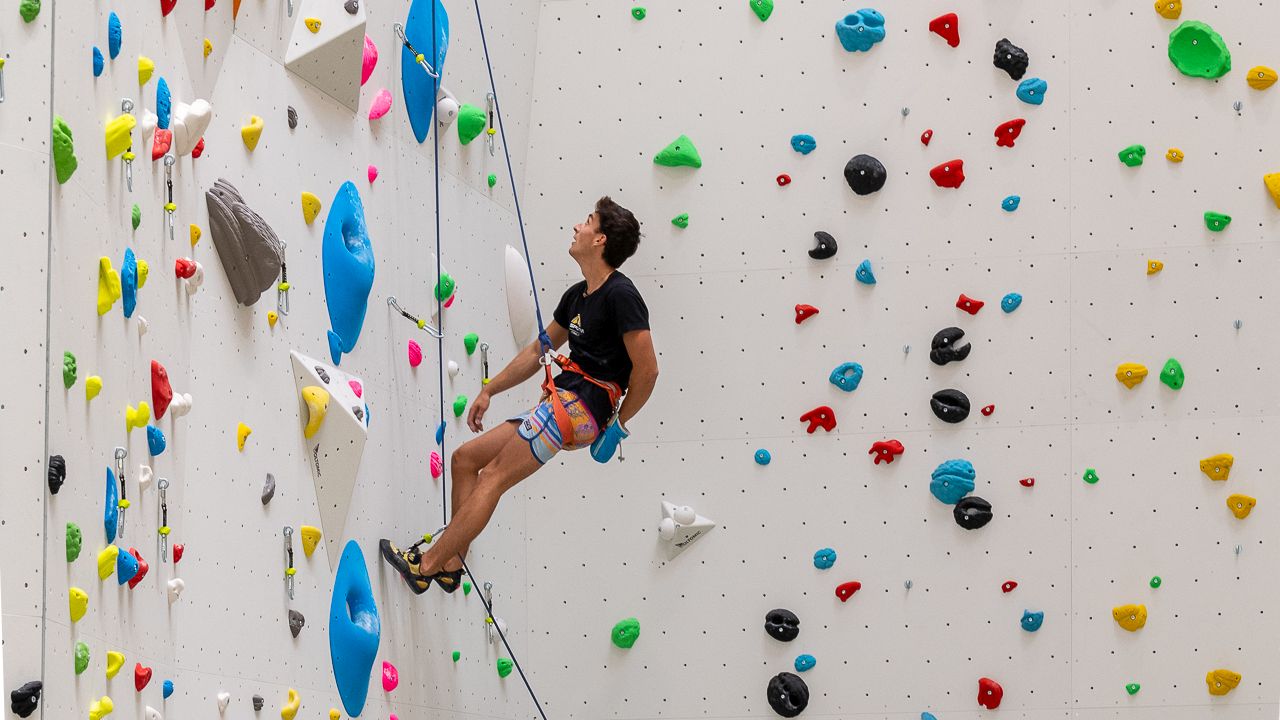 An athlete climbs on a climbing wall. 