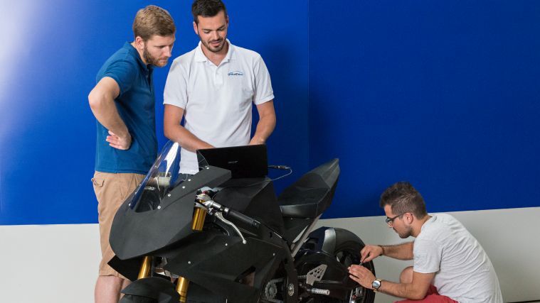 Students working on an electric motorbike. Students working on an electric motorbike.