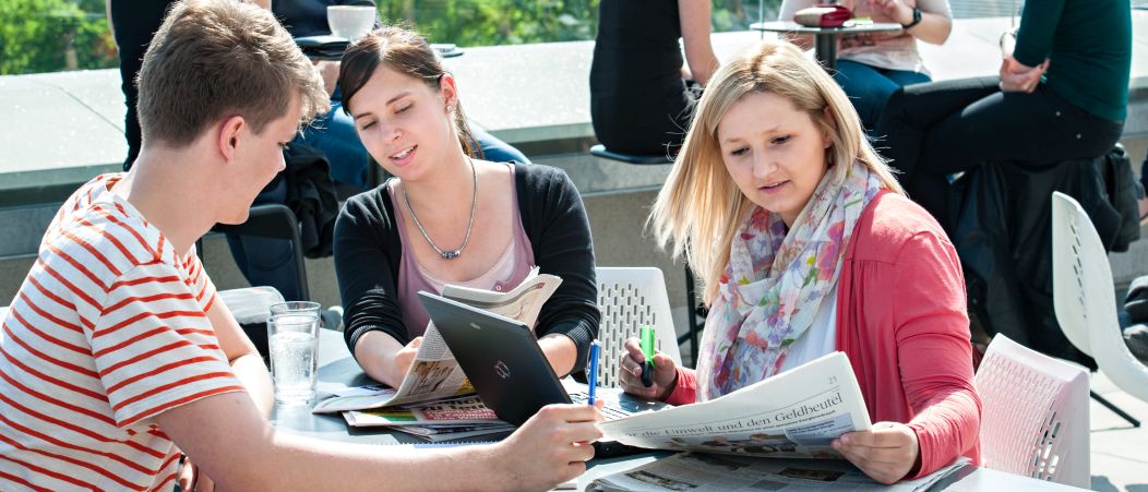 Studierende bei der Wohnungssuche. Studierende sehen sich Wohnungsanzeigen an.